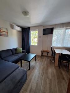a living room with a couch and a table at Бобс апартаменти 1 in Kiten