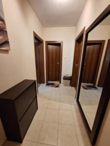 a hallway with two doors and a mirror at Бобс апартаменти 1 in Kiten