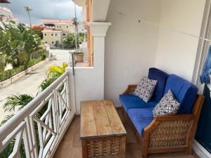 uma varanda com um sofá azul e uma mesa em Riche luxury em Punta Cana