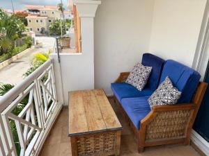 um sofá azul e uma mesa numa varanda em Riche luxury em Punta Cana mais 6 fotografias