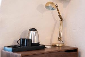 una macchinetta del caffè e una lampada su un tavolo di Casa Tre Archi - Malva ad Altamura