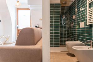 e bagno con lavandino, servizi igienici e piastrelle verdi. di Casa Tre Archi - Malva ad Altamura