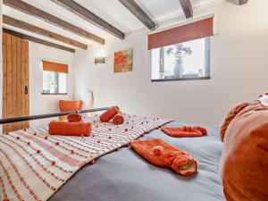 a bedroom with a bed with orange pillows on it at 4 Bed in Lanhydrock 90215 in Bodmin