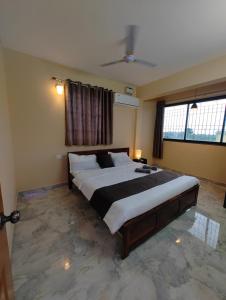 a bedroom with a large bed and two windows at Casa Santana in Dabolim