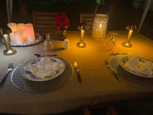 a table with two plates and candles on it at Romantic Dome & French Cuisine in Jantetelco