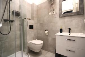 a bathroom with a shower and a toilet and a sink at Rently Apartments in Old Town in Kraków