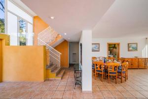 Villa Angela Flores by Villa Plus في تيولادا: غرفة طعام بها طاولة وكراسي