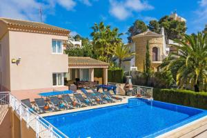 Villa Angela Flores by Villa Plus في تيولادا: فيلا مع مسبح ومنزل