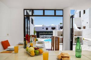 een eetkamer met een tafel met eten en drinken bij Villa Anjharad by Villa Plus in Puerto del Carmen