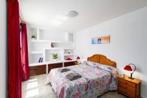 een slaapkamer met een bed, een dressoir en planken bij Villa Anjharad by Villa Plus in Puerto del Carmen +32 foto's