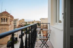 a balcony with a table and chairs looking out at a city at Centre Ville Local Stays in Argos