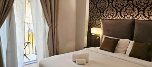 a hotel room with a bed and a window at STOA ROME Boutique Suites in Rome