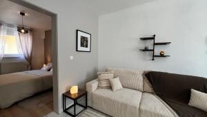 a living room with a couch and a bed at Gîte Le 25 in Ingersheim
