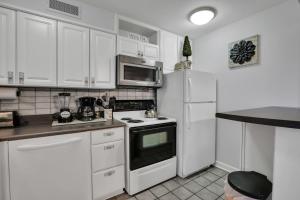 eine Küche mit weißen Schränken und einem Herd mit Backofen in der Unterkunft 1BR 7-O - Cozy Downtown Atlanta Condo in Atlanta