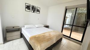 亚美尼亚Spacious apartment in the North on Av 19 Norte的一间带床和窗户的白色卧室