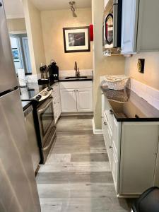 アトランタにある3H The Sweet Suite at Peachtree Towersの白いキャビネットと黒いカウンタートップを備えたキッチン