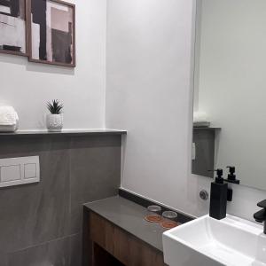 a bathroom with a sink and a mirror at 423 Menlyn maine Apartment in Pretoria