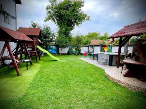 a yard with a playground with a green slide at La Mateo in Călimăneşti