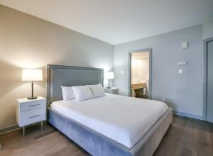 une chambre avec un grand lit blanc et un bureau dans l'établissement 2BR King Suite Pool Sauna Heated Pool, à Shanty Bay