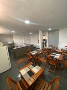 an empty cafeteria with tables and chairs and a refrigerator at Hotel Amazonas in Canaã dos Carajás