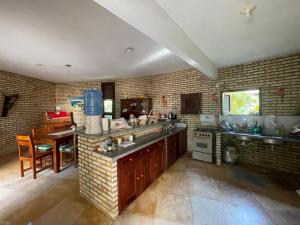 a large kitchen with a counter and a dining room at Casa Redonda in Beberibe