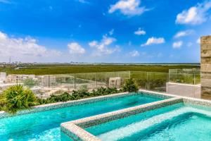una piscina en la parte superior de un edificio con vistas en Riva Puerto Cancun # 207, Halibut, en Cancún