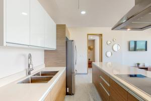 una cocina con fregadero y refrigerador en Riva Puerto Cancun # 207, Halibut, en Cancún