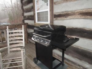 a stove and a chair in front of a house at Lookout Mtn cabin with a view in Rising Fawn