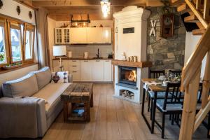 a living room with a couch and a fireplace at Domek 'Słoneczna 2' z RUSKĄ BANIĄ in Kluszkowce