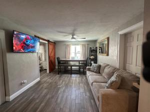 a living room with a couch and a flat screen tv at Deland Serenity Place #1 in DeLand