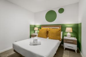 a bedroom with a bed with yellow and green walls at Living Central Stay Bejeque in Vecindario