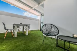 a room with a table and chairs and grass at Living Central Stay Bejeque in Vecindario