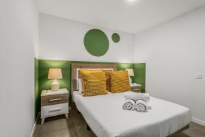 a bedroom with a white bed with yellow pillows at Living Central Stay Bejeque in Vecindario