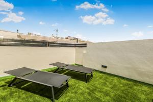 two picnic tables on the grass next to a wall at Living Central Stay Bejeque in Vecindario +6 photos