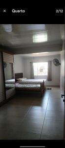 a bedroom with two beds and a window at Quarto Pedreira Mauriti in Belém