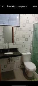 a bathroom with a toilet and a sink and a mirror at Quarto Pedreira Mauriti in Belém