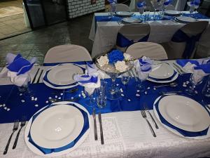 Una mesa puesta con platos y cubiertos azules y blancos. en Oppiplot Guest House, en Kempton Park