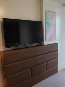 a flat screen tv sitting on top of a dresser at Relaxing Escape lovely STUDIO unit with a pool in Tagaytay +14 photos