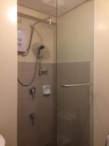 a shower in a bathroom with a glass door at Relaxing Escape lovely STUDIO unit with a pool in Tagaytay