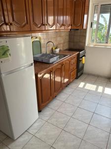 a kitchen with a white refrigerator and wooden cabinets at White Marine Hotel in Qeparo