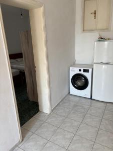 a kitchen with a washing machine and a washer at White Marine Hotel in Qeparo