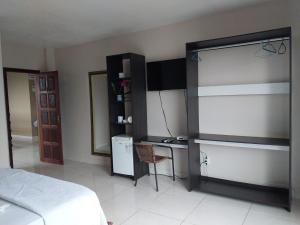 a bedroom with a bed and a desk and a refrigerator at Elite Flat Hotel in São Gabriel da Cachoeira
