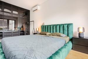 a bedroom with a large bed with a green headboard at Garden Oasis in City Center in Belgrade