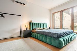 a bedroom with a large bed with a green headboard at Garden Oasis in City Center in Belgrade +18 photos