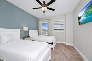a bedroom with two beds and a ceiling fan at Inviting Home Near Disney With Waterpark & Resort Access At Encore Resort - 7792Sw in Kissimmee +26 photos