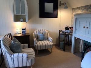 a living room with two chairs and a table at Ardmore House B&B in Lochinver