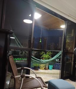 a room with a chair and a window with plants at Edifício Montpellier in Curro Velho