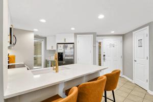 Una cocina con encimera y sillas blancas. en Oceanfront Villa Direct Beach Access, en Hilton Head Island