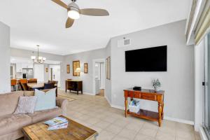 Una sala de estar con un sofá y un televisor de pantalla plana. en Oceanfront Villa Direct Beach Access, en Hilton Head Island