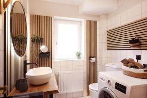 une salle de bain avec un lavabo et une machine à laver dans l'établissement Im Bad, strandnah und zentral, à Sankt Peter-Ording 20 autres photos